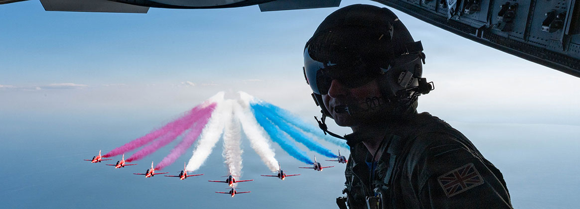 Picture of a pilot on a C-17 with the Royal Air Force flying behind him